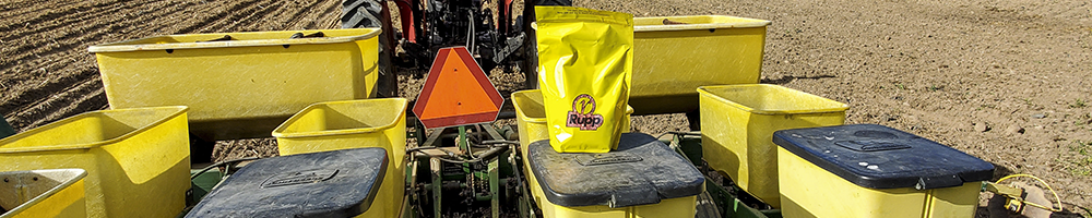 Tractor and planter with bag of Rupp sweet corn seed.